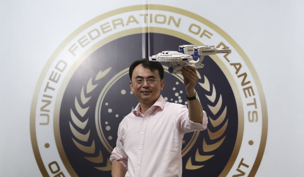 Liu Dejian, chairman of NetDragon Websoft, at his office holding a model of the USS Enterprise. Photo: May Tse