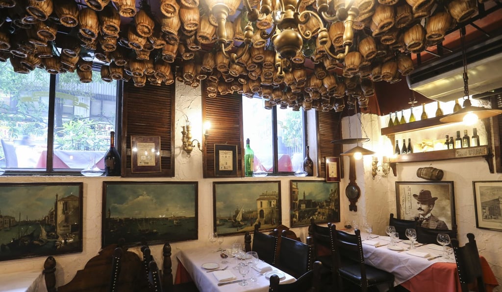 Wine bottles hang from the ceiling in La Taverna. Photo: Dickson Lee