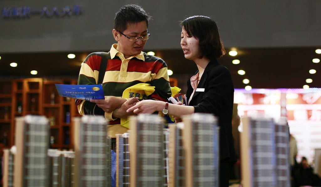 A salesperson talks to a customer behind models of a residential compound at a real estate exhibition in Wuxi, the city just named by research house Hurun Report as seeing a 22. 9 per cent rise in prices in the 12 months to June 30, exceeding Hong Kong’s 20.8 per cent rise. Photo: Reuters