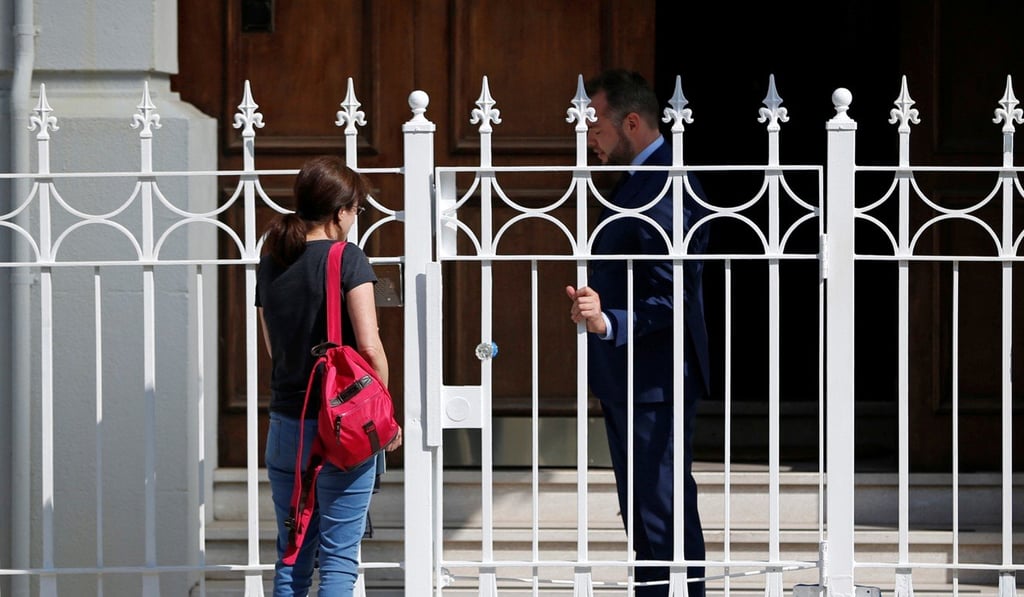 An unidentified woman talks with a man outside the gate at the entrance to the building of the Consulate General of Russia in San Francisco, California, which has been ordered shut by Washington. Photo: Reuters