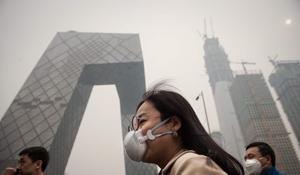 A woman wearing a protective pollution mask walk outside the headquarters of China’s state broadcaster in Beijing. Photo: AFP