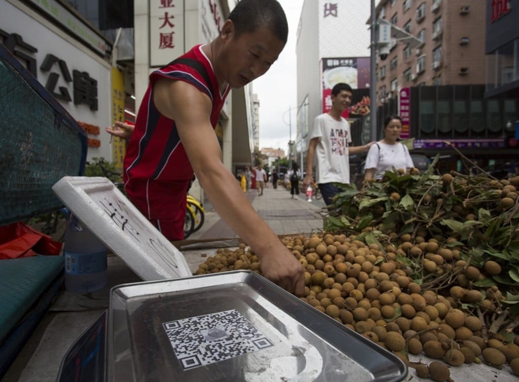 Fruit vendor Huang Zhaoyong displays a QR code for mobile payment on a street in Shenzhen. Photo: May Tse Fruit vendor Huang Zhaoyong displays a QR code for mobile payment on a street in Shenzhen. Photo: May Tse