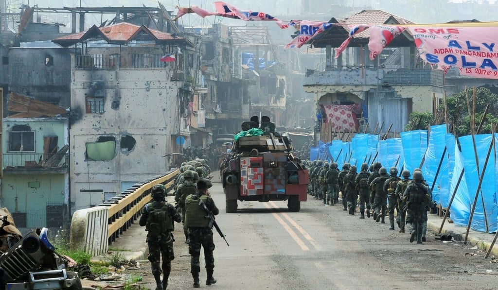 An armoured car and government troops march towards Mapandi bridge after 100 days of intense fighting between soldiers and insurgents in Marawi. Photo: Reuters