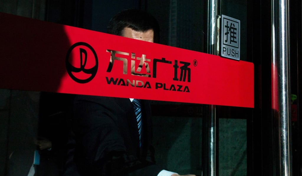 A man leaves the Wanda building in Beijing. Government regulators have been reining in the asset acquisitions of powerful conglomerates such as the Wanda Group, amid fears they are racking up dangerous debt levels. Photo: AFP A man leaves the Wanda building in Beijing. Government regulators have been reining in the asset acquisitions of powerful conglomerates such as the Wanda Group, amid fears they are racking up dangerous debt levels. Photo: AFP