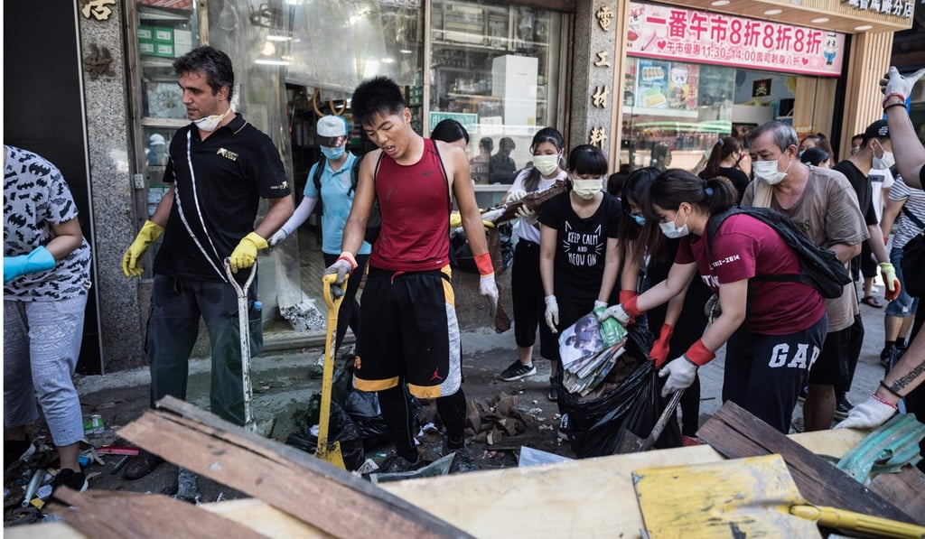 Residents clear debris and rubbish from a street in the aftermath of Typhoon Hato in Macau. Photo: AFP