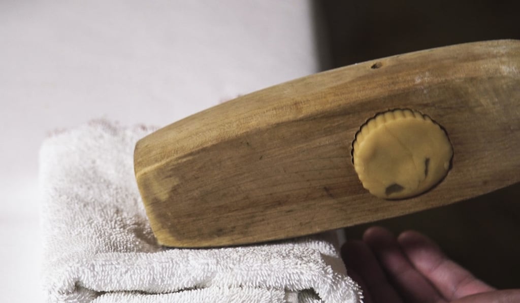A mooncake is pressed in a wooden mould.