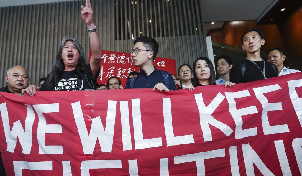 Leung (arm raised) with fellow ousted Hong Kong lawmakers Nathan Law, Lau Siu-lai, and Edward Yiu Chung-yim in July. Photo: Edward Wong