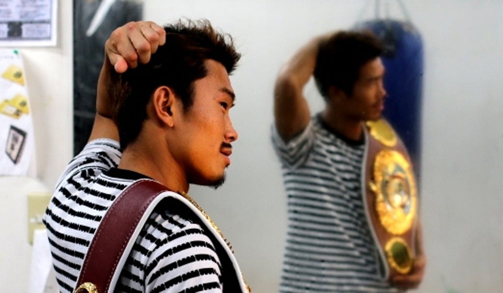 Sho Kimura and his WBO flyweight belt are reflected in the mirror at Aoki Gym in Tokyo. Photo: Unus Alladin