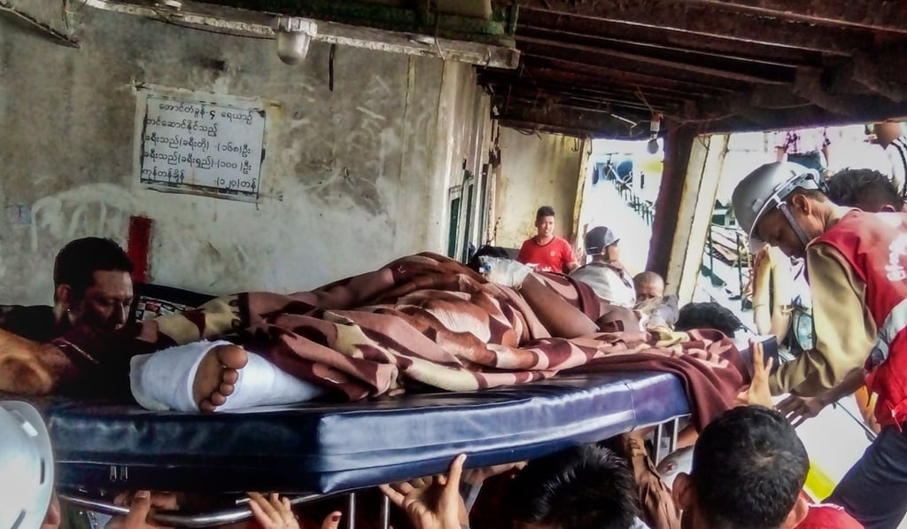 A Myanmar border policeman, allegedly hurt during confrontations with Rohingya militants, is carried on a stretcher as he arrives at the port in Sittwe on August 29. Photo: AFP