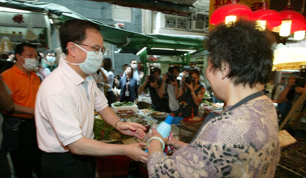 Former Hong Kong Chief Secretary Donald Tsang Yam-kuen hands out bottles of bleach in 2003 during the city-wide cleanup campaign amid the deadly Sar outbreak. Photo: SCMP Picture