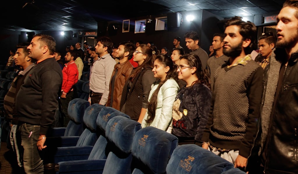 Audience members stand as the Indian national anthem is played at a theatre before the screening of a film, in the city of Jammu last December 13. Photo: AP