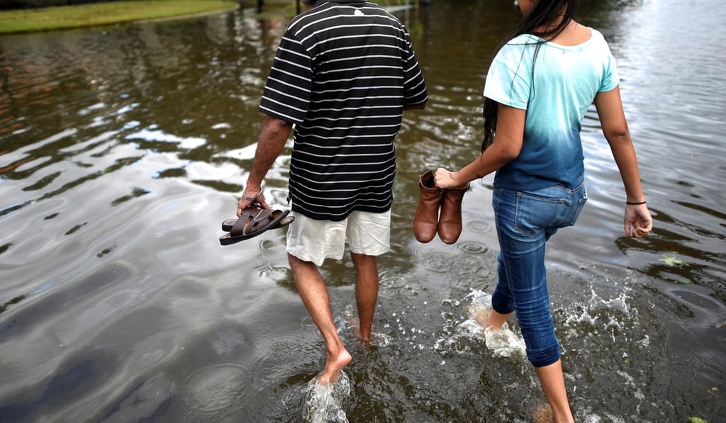 A father and daughter walk through floodwaters after Hurricane Irma in Jacksonville, Florida on Monday. Photo: Reuters