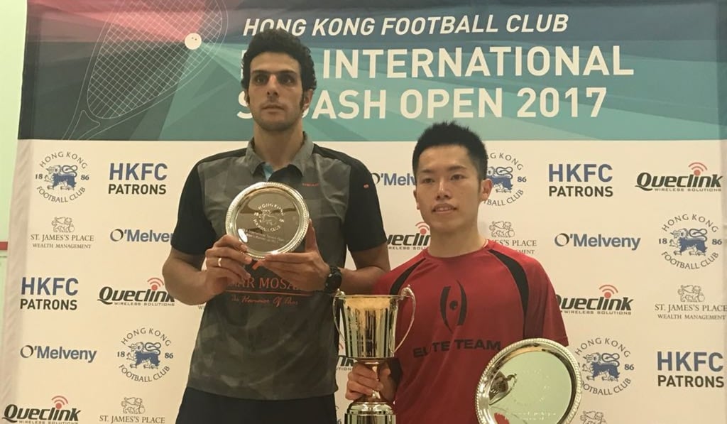 Omar Mosaad looks on stony-faced as Leo Au Chun-ming poses with the winner’s trophy.