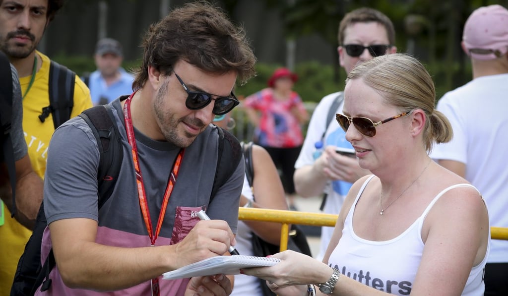 Fernando Alonso signs an autograph for a fan in Singapore. Photo: EPA Fernando Alonso signs an autograph for a fan in Singapore. Photo: EPA