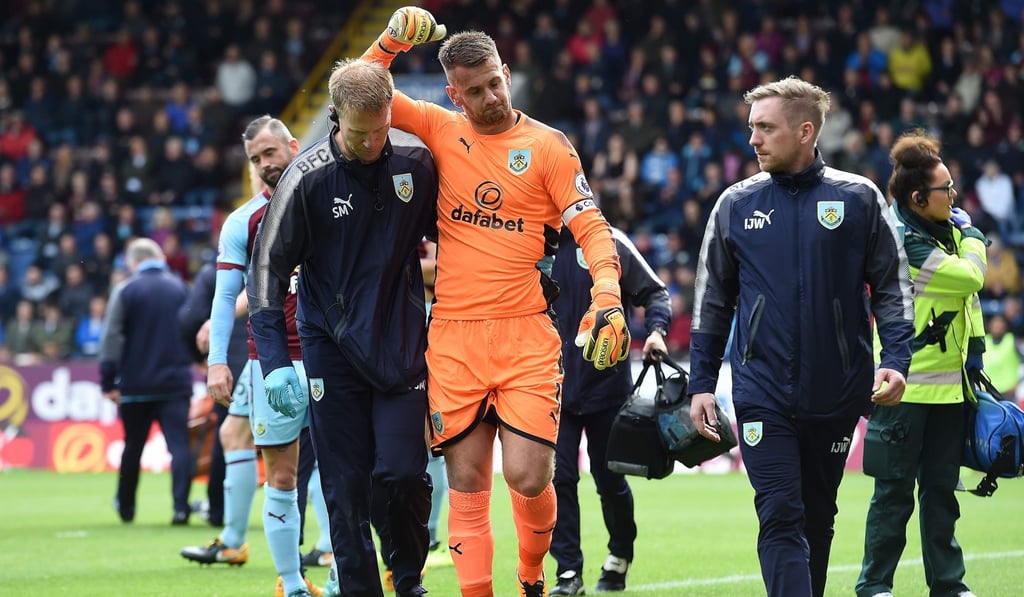 Burnley's English goalkeeper Tom Heaton (C) is helped off the pitch after receiving medical treatment during the English Premier League football match between Burnley and Crystal Palace. Heaton was injured in the play. Photo: AFP