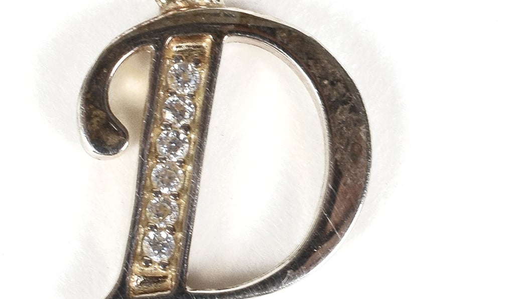 A charm in the shape of her first initial D, thought to have been worn as a teen by Princess Diana, that is among dozens of items with a direct connection to the princess sold at auction. Photo: RR Auction via AP