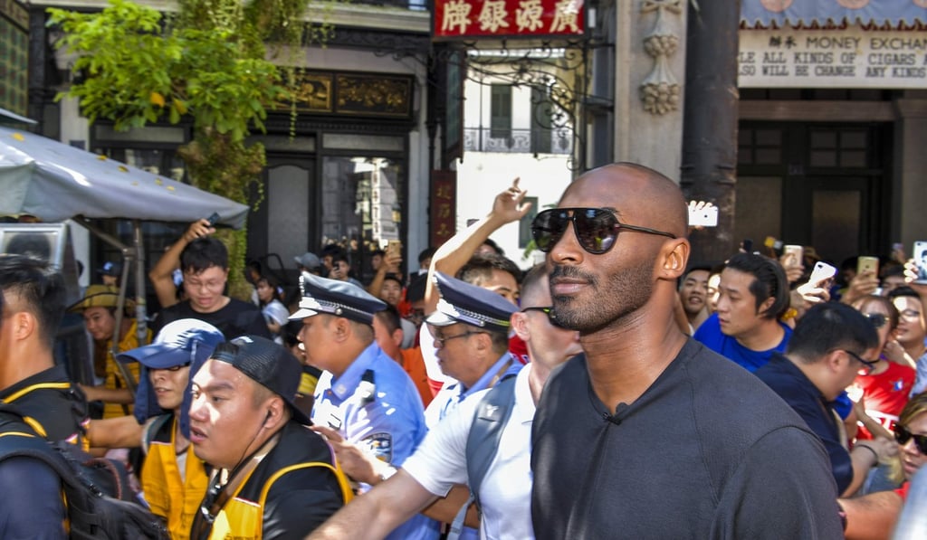 Former NBA basketball player Kobe Bryant is mobbed by fans in Haikou. Photo: AFP