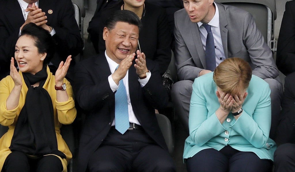President Xi Jinping and China’s first lady Peng Liyuan enjoy a football match with German Chancellor Angela Merkel. File photo: EPA