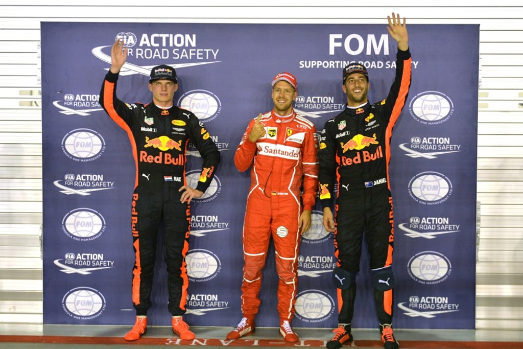 Ferrari driver Sebastian Vettel celebrates with Red Bull drivers Max Verstappen (L) and Daniel Ricciardo after qualifying. Photo: Xinhua