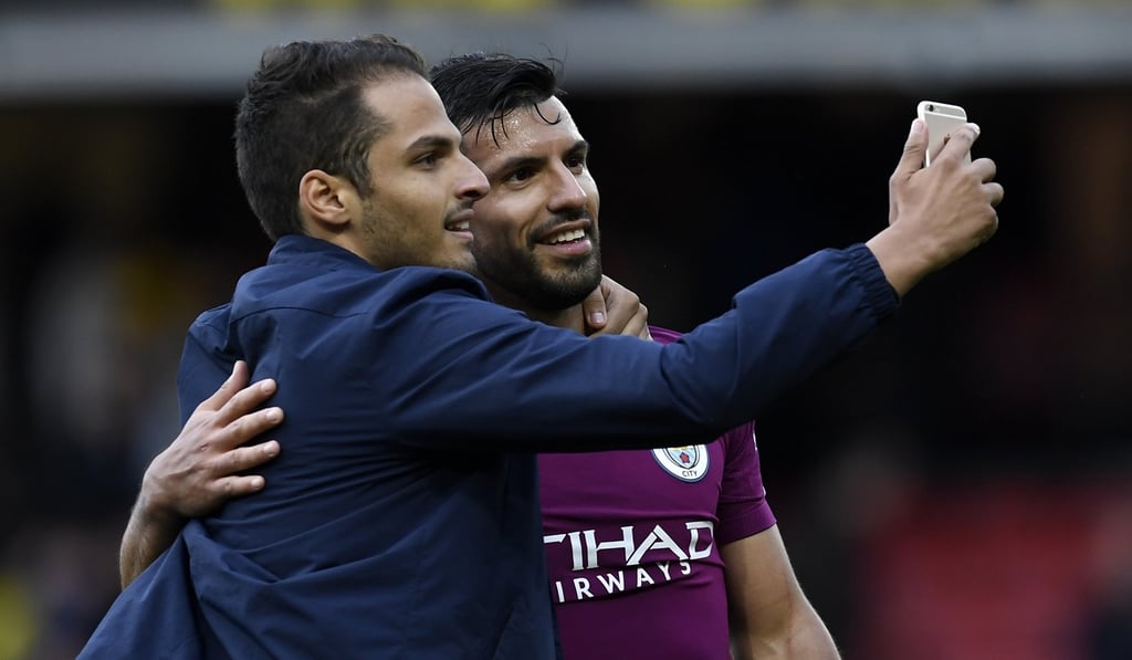 A spectator runs onto the pitch for a selfie with Manchester City’s Sergio Aguero. Photo: EPA