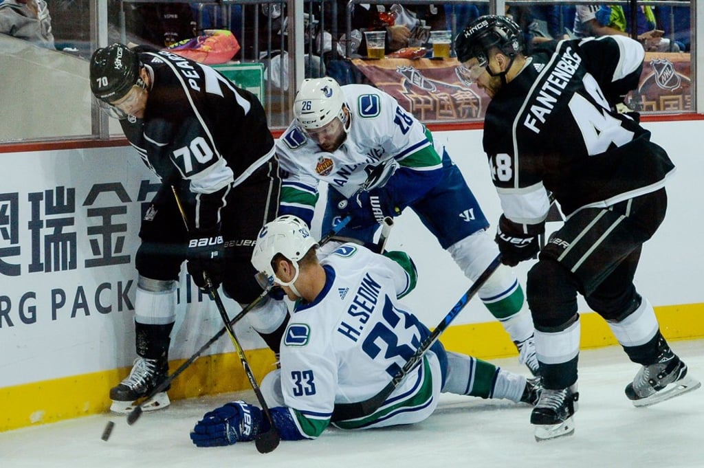 Los Angeles Kings players (black) challenge Vancouver Canucks players during the 2017 NHL China Games in Shanghai. Photo: AFP