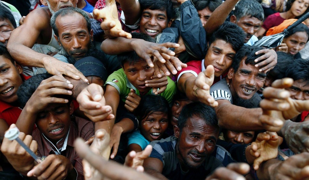 Rohingya refugees stretch their hands to receive aid distributed by local organisations at a makeshift camp in Cox's Bazar, Bangladesh on September 18, 2017. Photo: Reuters