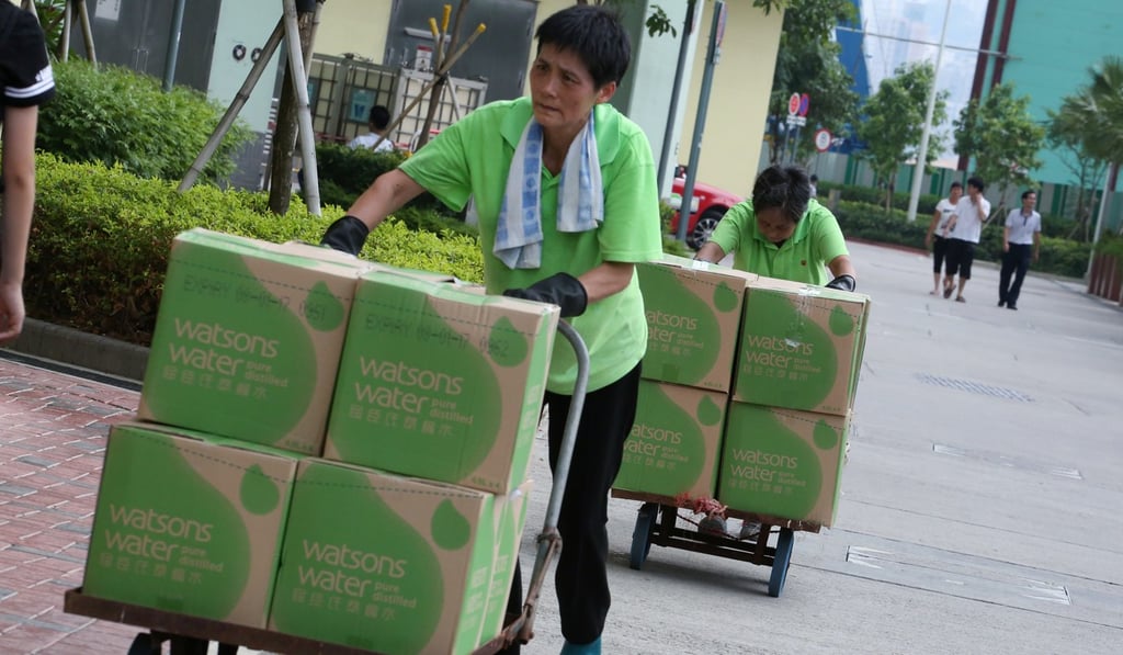 Workers carry bottled water to Kai Ching Estate in Kai Tak to distribute to residents. Photo: Felix Wong