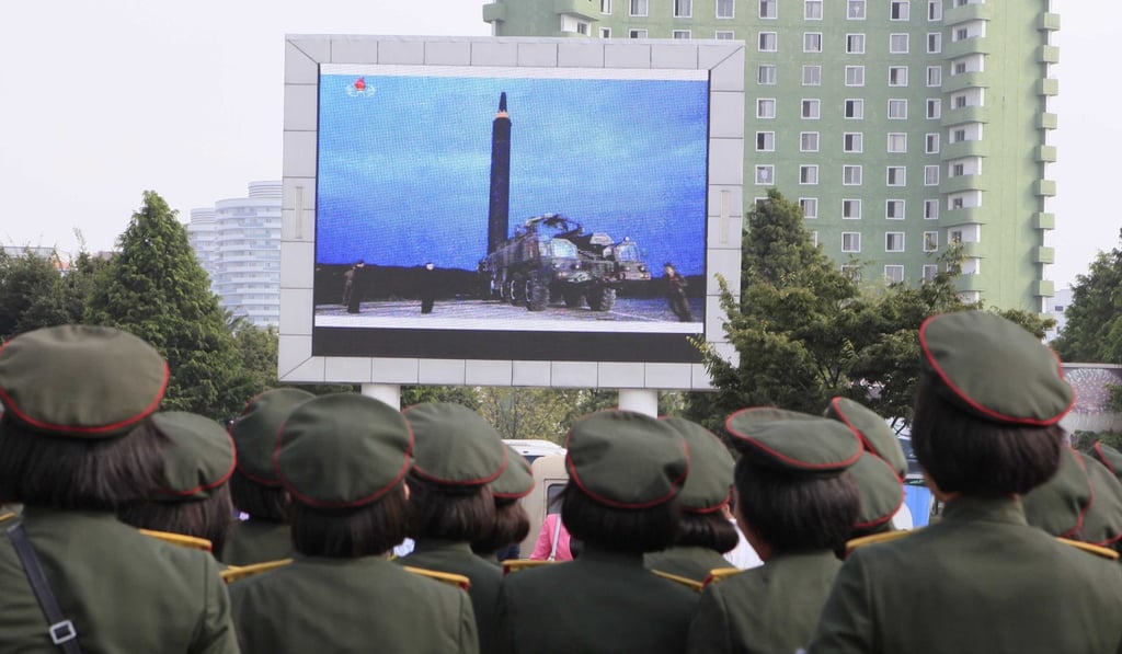 North Koreans watch a televised news broadcast of the test-fire of an intercontinental ballistic rocket. Photo: AP