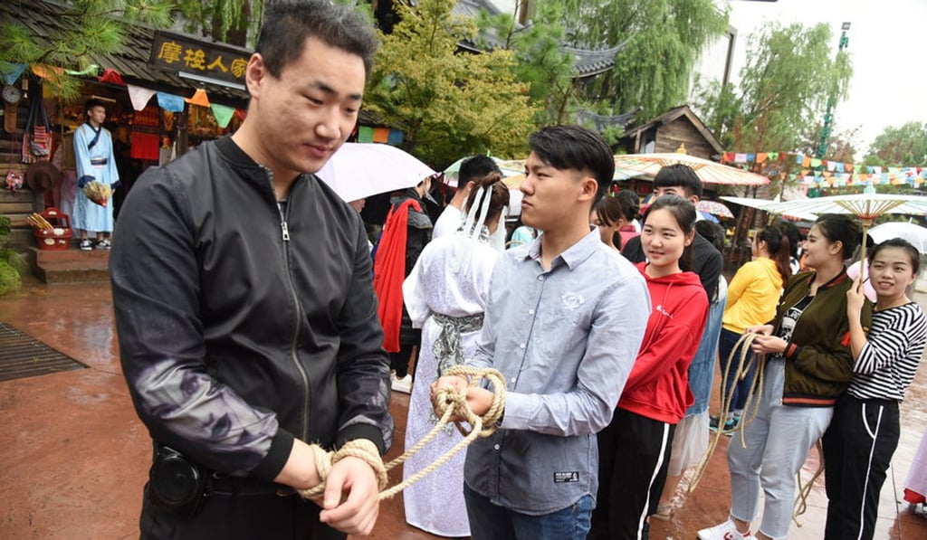 Another visitor is led through the park with roped hands. Photo: Handout