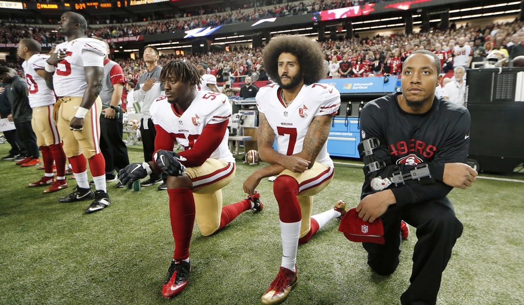 Colin Kaepernick (7) and outside linebacker Eli Harold (58) kneel during the playing of the national anthem last December. Photo: AP