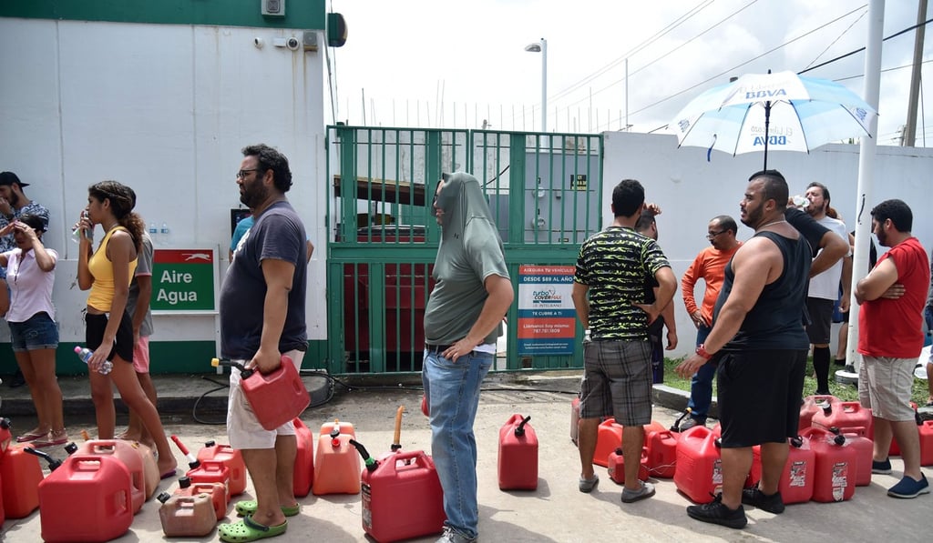 People waiting line to buy gas are seen in Rio Hondo, Bayamon, Puerto Rico, on September 22, 2017. Puerto Rico battled dangerous floods Friday after Hurricane Maria ravaged the island, as rescuers raced against time to reach residents trapped in their homes and the death toll climbed to 33. Photo: AFP