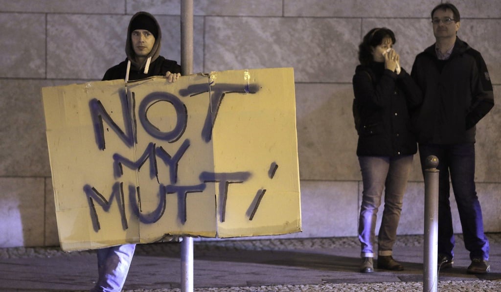 A demonstrator holds a poster reading “Not my Mum,” a play on Chancellor Angela Merkel’s nickname (“Mum”), on Sunday after the German election. Photo: AP