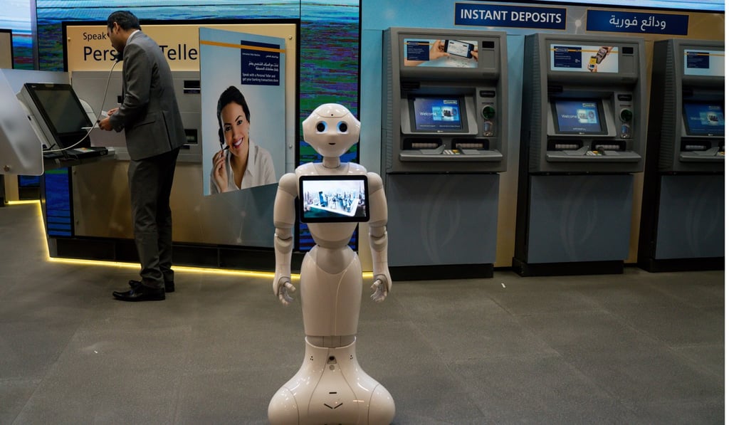 An information robot stands ready to assist customers in front of ATMs at an Emirates NBD bank branch in the Dubai Mall, in the United Arab Emirates, on September 12. Photo: Bloomberg An information robot stands ready to assist customers in front of ATMs at an Emirates NBD bank branch in the Dubai Mall, in the United Arab Emirates, on September 12. Photo: Bloomberg