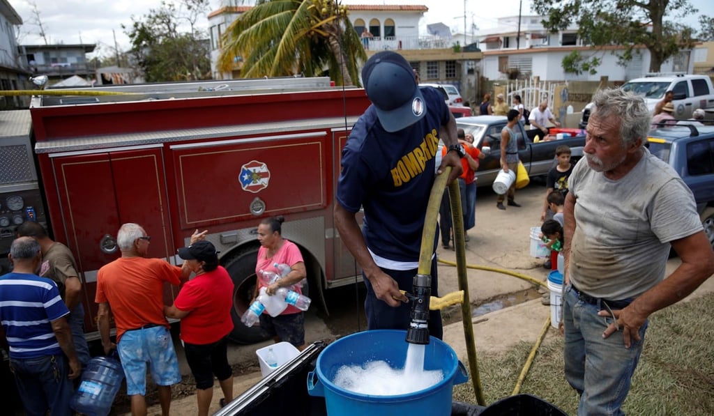 A fireman fills containers with water for residents of in Toa Baja, Puerto Rico, on Sunday. Photo: Reuters