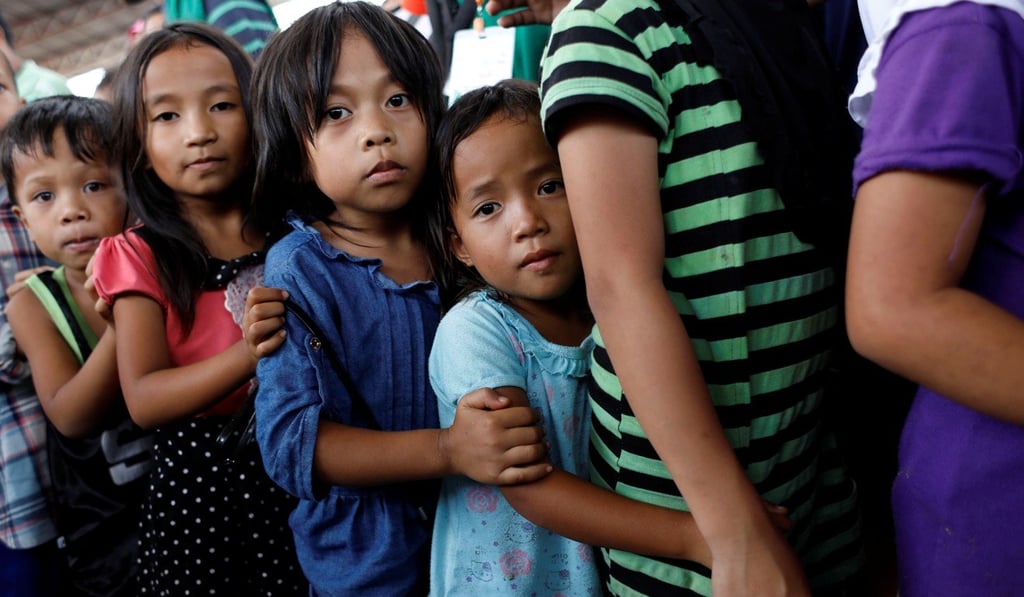 Children line up to receive lunch at an evacuation centre outside the city as army troops continue their assault against insurgents from the Maute group in Marawi city on July 5. Photo: Reuters