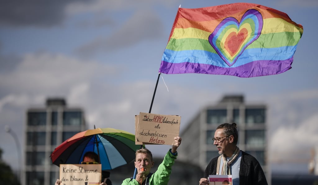 A woman carries a placard and waves a rainbow flag during a counter demonstration against an anti-gay-marriage rally in Berlin on September 15. Photo: EPA