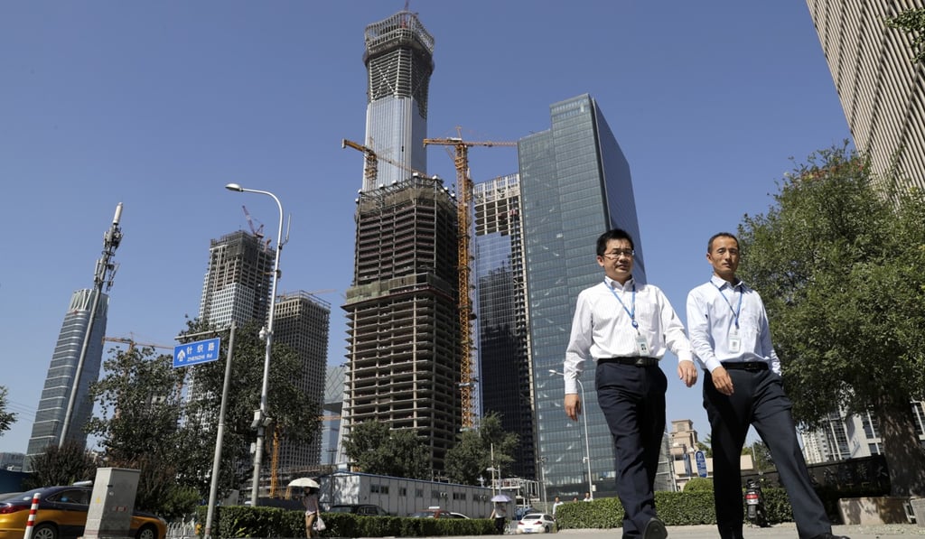 Chinese men walk in Beijing’s Central Business District. Photo: AP