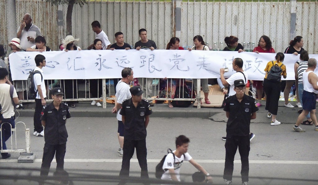 Protesters hold a banner in Beijing on July 24 after a crackdown on Shanxinhuia, a suspected pyramid sales scheme. Photo: Kyodo