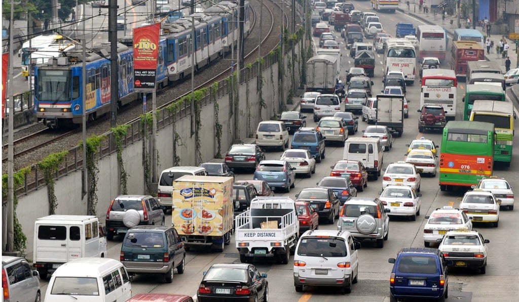 An electric elevated railway mass transport system runs above vehicles caught in a traffic jam on a Manila highway in the Philippines. Photo; AFP