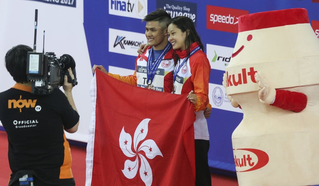 Kenneth To (left) and Stephanie Au hold the Hong Kong flag during the medal ceremony. Photo: Felix Wong