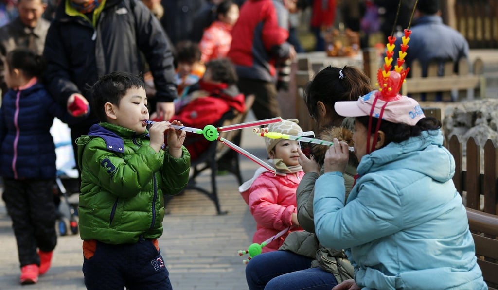 A boy plays games with his family during the temple fair for the Chinese Spring Festival at Taoranting Park in Beijing. Photo: EPA