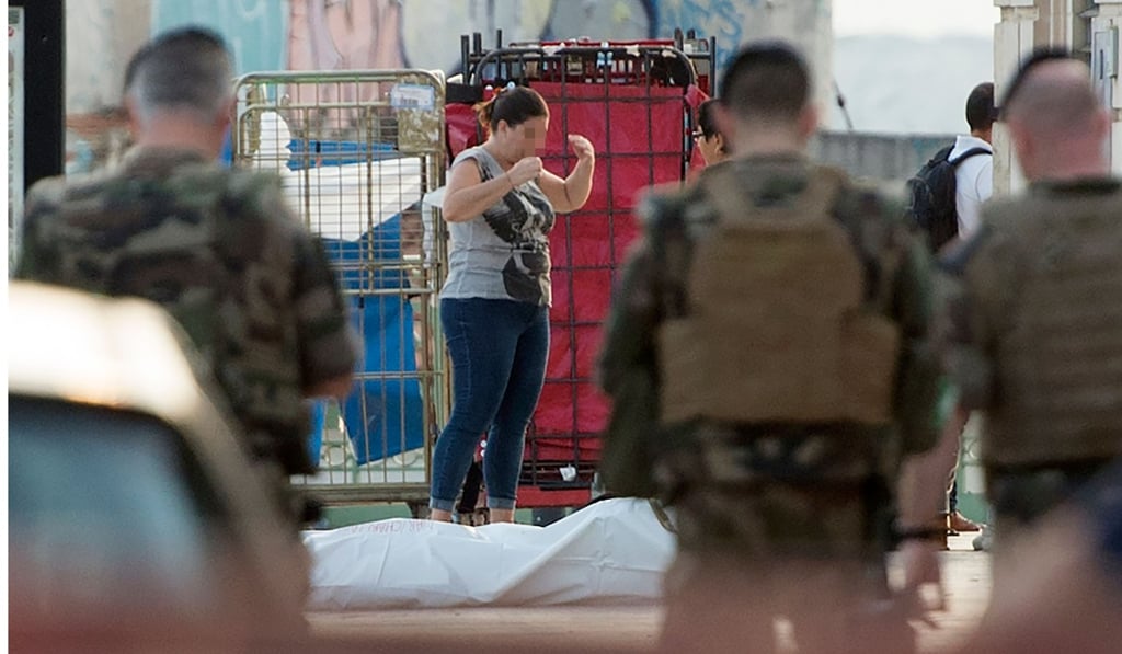 A woman stands next to a body outside Saint-Charles train station in Marseille. Photo: AFP A woman stands next to a body outside Saint-Charles train station in Marseille. Photo: AFP