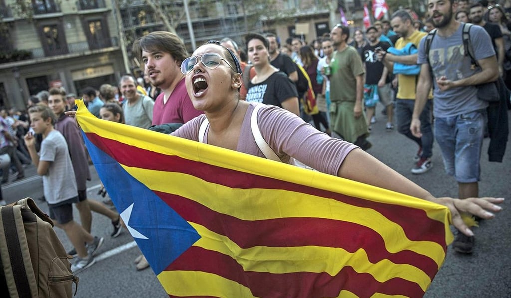 A woman carries an independence Catalan flag as demonstrators march downtown Barcelona, Spain, Tuesday Oct. 3, 2017. Thousands of people demonstrated against the confiscation of ballot boxes and charges on unarmed civilians during Sunday's referendum, declared illegal by Spain's Constitutional Court, on Catalonia's secession from Spain. Photo: AP A woman carries an independence Catalan flag as demonstrators march downtown Barcelona, Spain, Tuesday Oct. 3, 2017. Thousands of people demonstrated against the confiscation of ballot boxes and charges on unarmed civilians during Sunday's referendum, declared illegal by Spain's Constitutional Court, on Catalonia's secession from Spain. Photo: AP