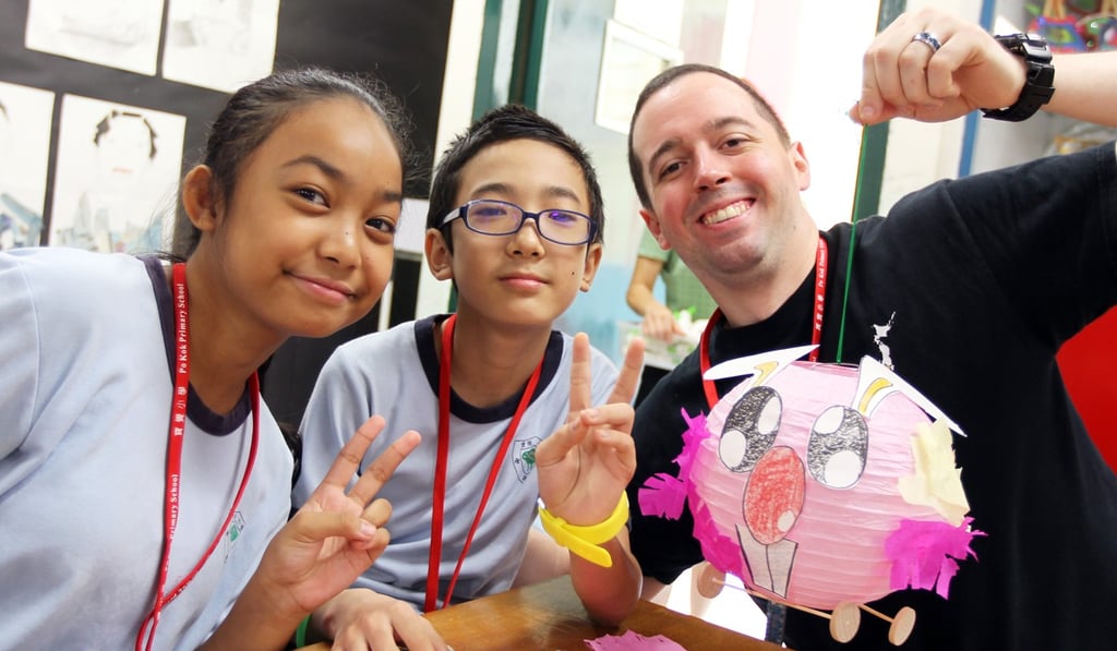 (From left) Pupils Marikyle Jheizhel and Bidhan Rai make a paper lantern with navy officer Nicholas Marcantonio. Photo: Roy Issa