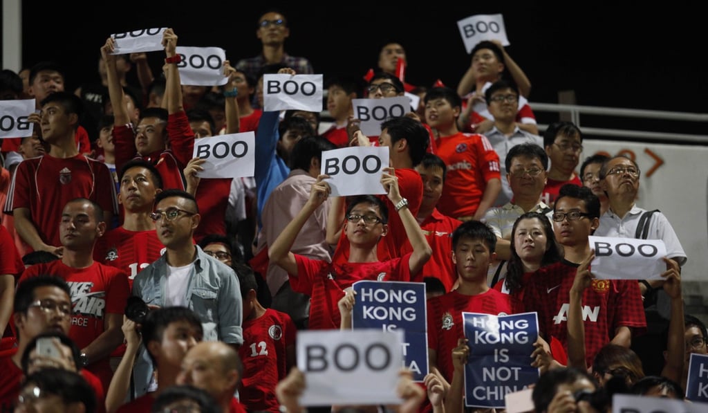 Hong Kong fans hold up signs that read