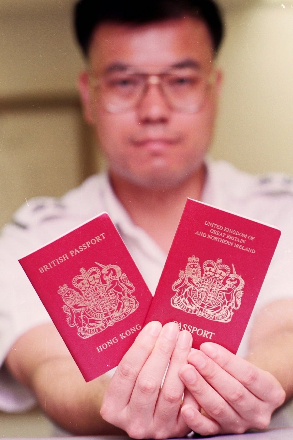 A Hong Kong immigration officer holds up British National Overseas (left) and British Dependent Territories Citizen passports, in June 1993. Photo: SCMP Pictures