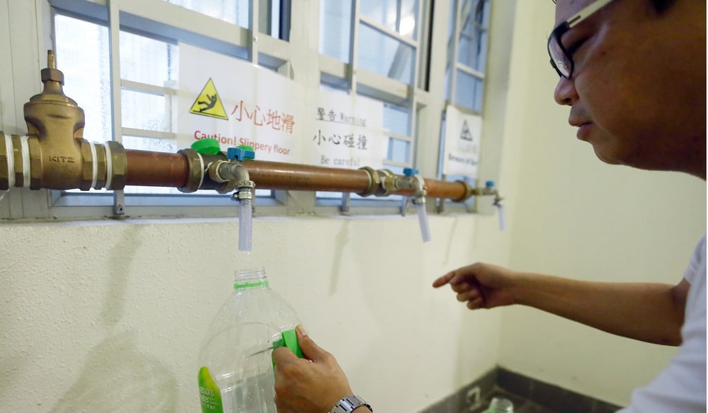 A man fetch water from the newly temporary pipes on a floor at Yan Ching House in Kai Ching Estate. Photo: Sam Tsang