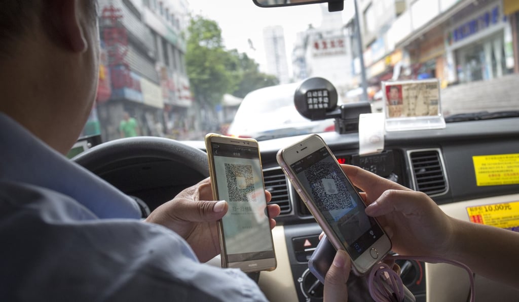 A passenger pays for her taxi ride using her mobile in Shenzhen, China. Photo: May Tse