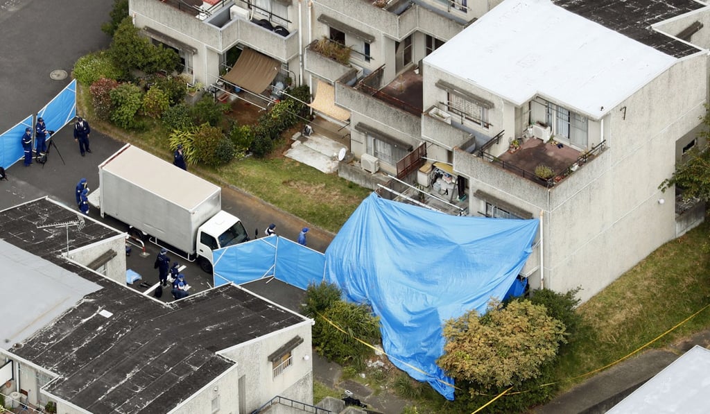 Plastic blue sheets cover a flat where bodies were found after a fire in Hitachi, Ibaraki prefecture. Photo: Kyodo