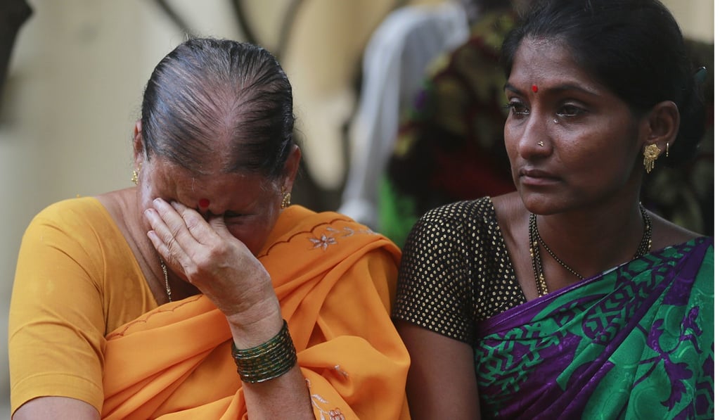 Indians mourn outside a morgue for relatives killed in a pedestrian bridge stampede, in Mumbai, India. Photo: AP